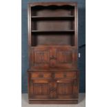 A carved oak bookcase on cupboard and drawer base with linen fold decoration. (194cm x 94cm x 50cm)