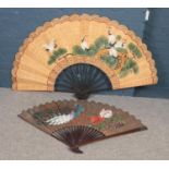 Two large hand painted oriental fans. One decorated with cranes, the other with peacocks. (Largest