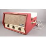 A Dansette 'Conquest Auto' portable record player (missing legs) in red and cream. H:25.5cm, W: 40.