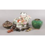 A selection of oriental items - to include a ceramic figure holding a fish, three carved hardwood