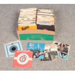 A box of 1970s single records.