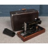 A cased electric Singer sewing machine.