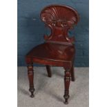 A Victorian gillows style carved mahogany hall chair on turned supports. Split to wood on the seat.