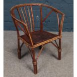 A child's Bamboo & hardwood chair with leather patterned seat. H: 48cm, W: 39cm, D: 26cm.