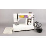A Toyota sewing machine - to include instruction manual & foot pedal. H: 31cm, W:37cm, D: 15.5cm.