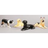 A group of Beswick dog figures. Border Collie, German Shepherd Lying, Black Labrador lying, Golden