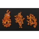 A collection of assorted polished amber necklace beads ranging in color from cognac through to