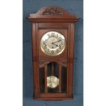 A carved oak Muller & Co. wall clock.