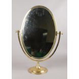 A large oval brass vanity mirror on stand. (Height 58cm).