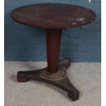 A circular mahogany Regency table raised on tapering support. (diameter 77cm) In tired condition.
