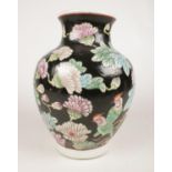 A large Chinese baluster shaped famille noir vase. Decorated with birds and flowers. H: 31cm.