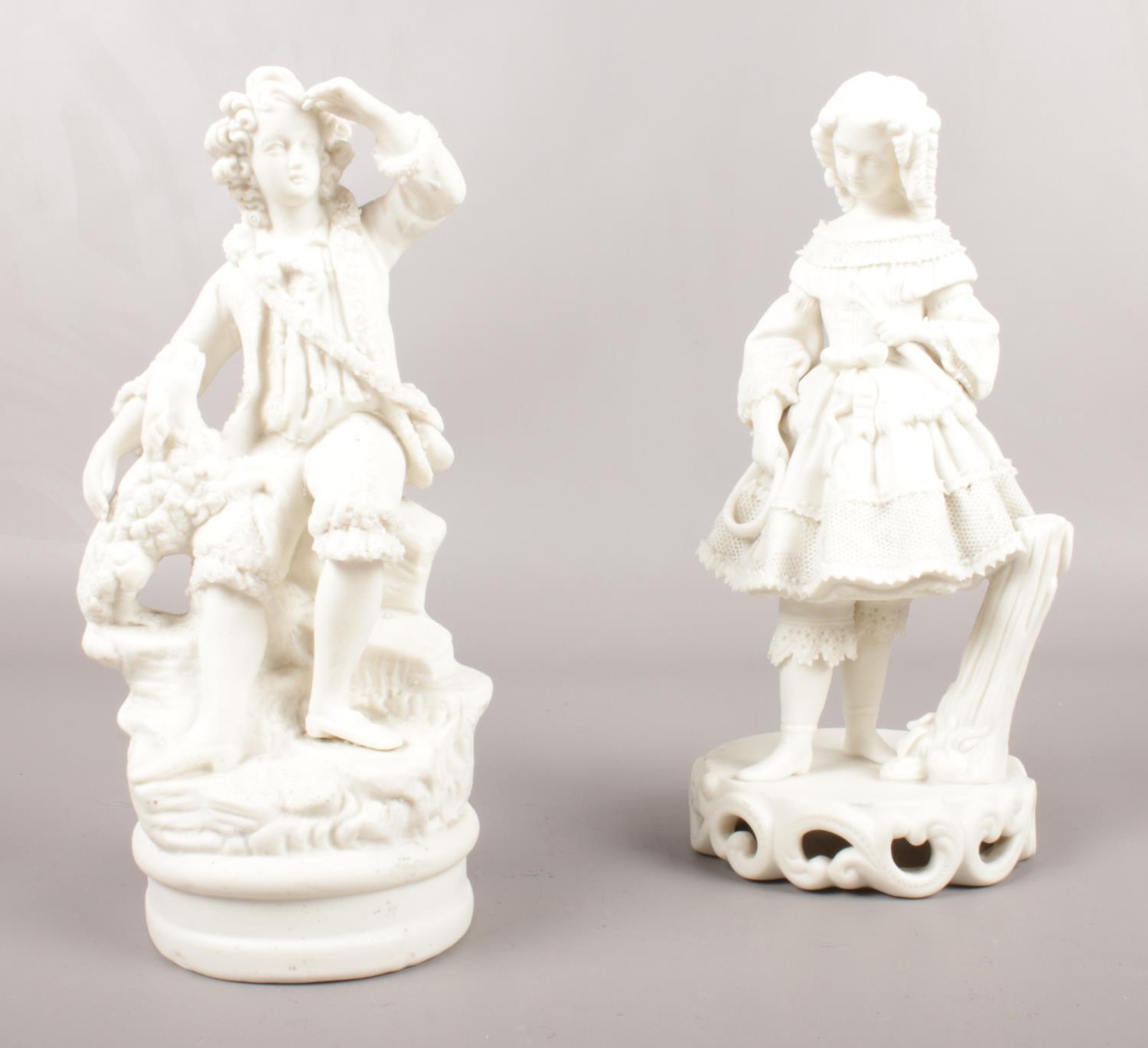 Two Parian figures. A girl with hoop & stick 23cm height, a boy with dog 22cm height.