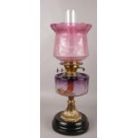 A Victorian brass & glass oil lamp. Cranberry glass shade, by Sherwood Birmingham. 57cm height.