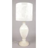 A large alabaster table lamp with floral decoration. (Height 59cm).