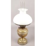 A brass oil lamp with milk glass shade.