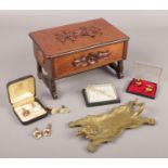 A wooden jewellery box and contents of collectables. Includes brass lion skin rug dish, brooches and