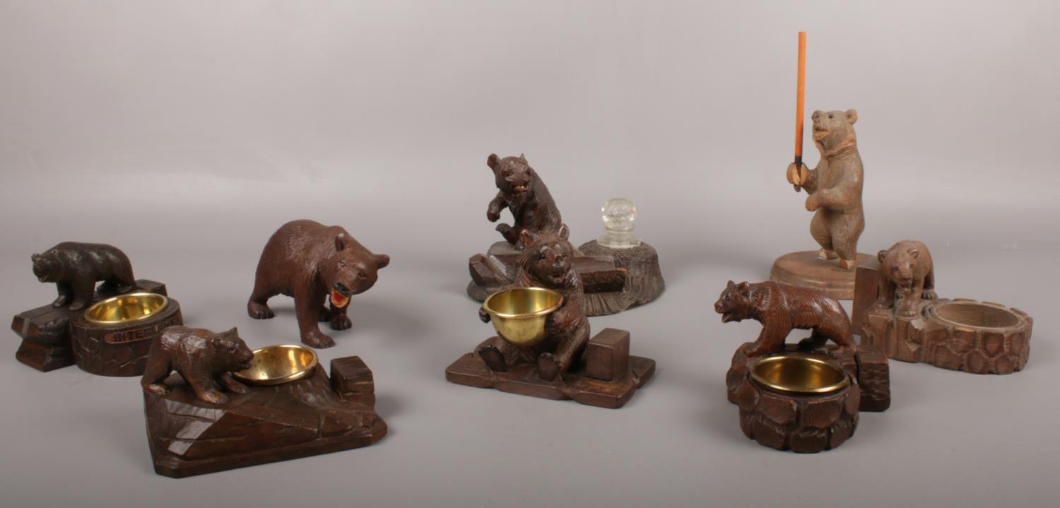 A collection of eight carved wood black forest bears. bear holding brass bowl example.