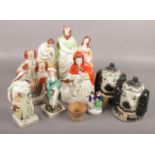 A group of nine Staffordshire figures. To include two double sided lidded dog jars, a figure of