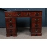 A reproduction Mahogany kneehole desk with green leather inset top. Eight assorted drawers,