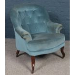 An early 20th century nursing chair with buttoned upholstery.
