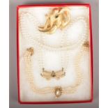 A Christian Dior faux pearl costume necklace along with a similar example and a gilt elephant