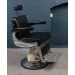 A Vintage Bellmont Apollo Art Deco style adjustable barbers chair upholstered in black with cream