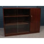 An early to mid century wooden bookcase. Comprising of glass sliding doors and side cupboard. H: