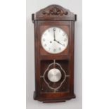 A carved oak eight day wall clock. Striking on a gong. Movement cleaned and serviced.