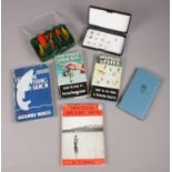 A quantity of fly fishing hooks and books. Including How to use the Spool Reel, Light line fly