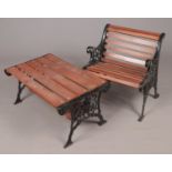 A cast iron and wood garden chair along with a matching table.