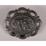 An antique Vulcanite brooch with floral decoration.