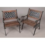 A pair of cast iron and wood garden chairs.