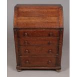 An oak bureau with fitted interior and four drawers.