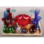 A tray of coloured glassware. Including bowl, vases, paperweights, candlesticks, etc.
