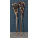Two vintage wooden Lacrosse sticks.