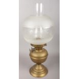 A brass and glass oil lamp with etched glass decoration.