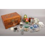 A wooden carved box with contents. To include a Caithness glass perfume spritzer, two hip flasks and