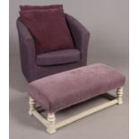 A modern amethyst velvet upholstered armchair along with similar footstool.