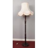 A carved Mahogany standard lamp with shade.