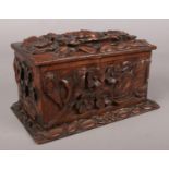 A carved wooden box with floral decoration. Repairs to edges.