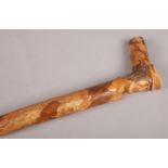 A carved wooden oriental stick. With dragon and mask decoration.