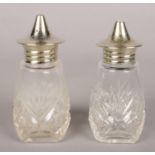 A pair of silver and glass salt and pepper shakers. Hallmarks faded.