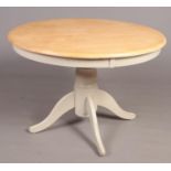 A part painted beech circular dining table.