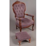 A carved mahogany spoon back armchair with amethyst upholstery along with matching footstool.