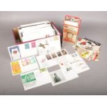 A box of stamps and postcards. To include a box of mint 1st day cover stamps from Jersey and one