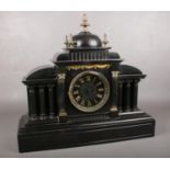 A Victorian black slate mantle clock. Comprising of an architectural case with central dome, three