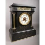 A large black slate mantle clock. Comprising of gilt metal columns and classical decoration. A white