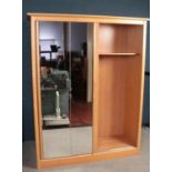 A large Beechwood double wardrobe with twin sliding mirrored doors (164cm width, 214cm height, 62.