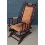 A Mahogany American Rocker. Raised on sleigh base with sprung rock action, upholstered seat with