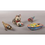 A group of tin plate toys. Kitten with ball, two birds, speed boat.